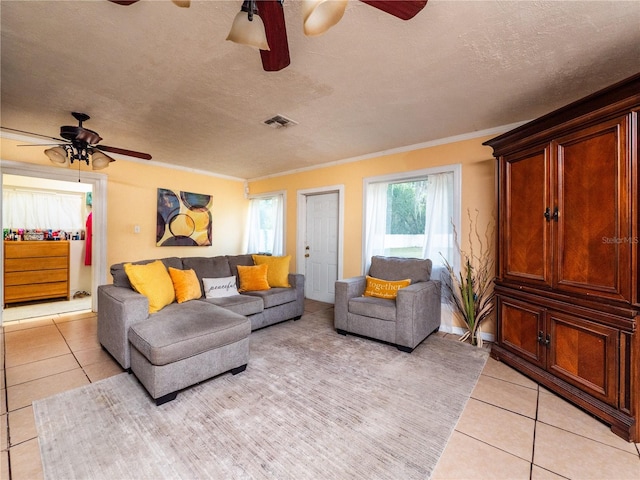 living room with crown molding, light tile patterned floors, and ceiling fan