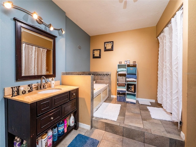 bathroom featuring vanity, a tub to relax in, and a textured ceiling