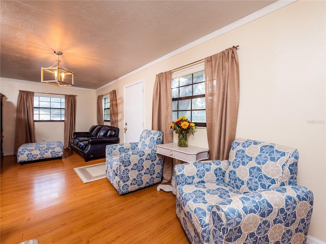 living area with crown molding and wood-type flooring