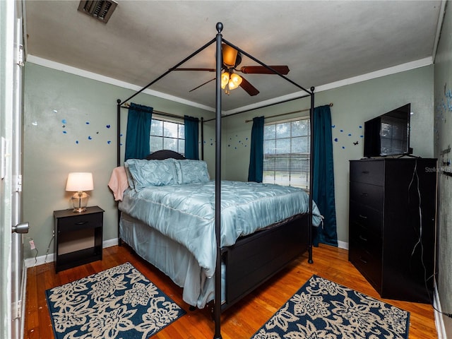 bedroom featuring crown molding, hardwood / wood-style flooring, and ceiling fan