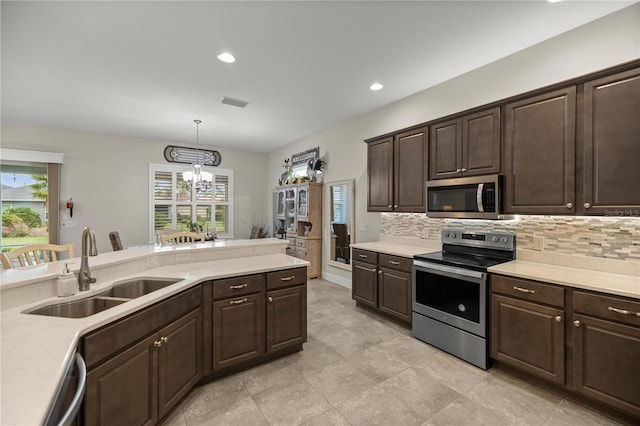 kitchen featuring appliances with stainless steel finishes, decorative light fixtures, dark brown cabinets, sink, and a chandelier