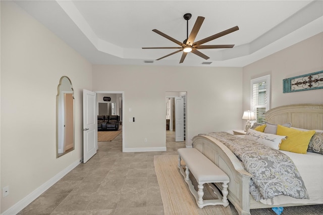 bedroom featuring ceiling fan and a raised ceiling