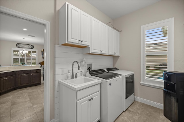 clothes washing area with a wealth of natural light, sink, and washer and dryer