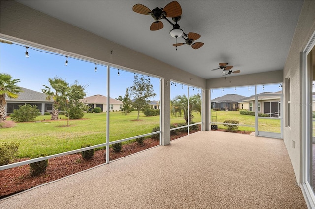 unfurnished sunroom with ceiling fan