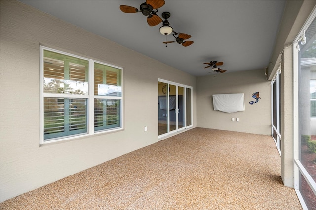 unfurnished sunroom featuring ceiling fan