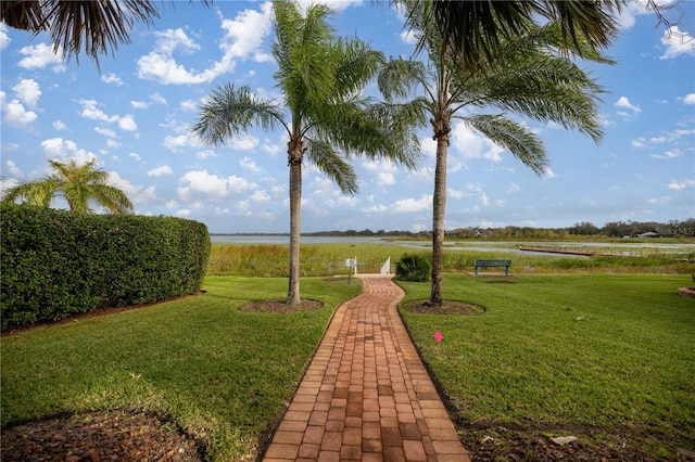 view of home's community with a lawn and a water view