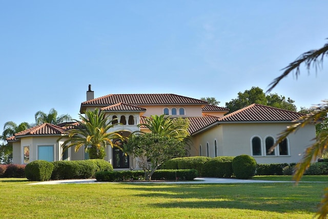 mediterranean / spanish home featuring a front yard