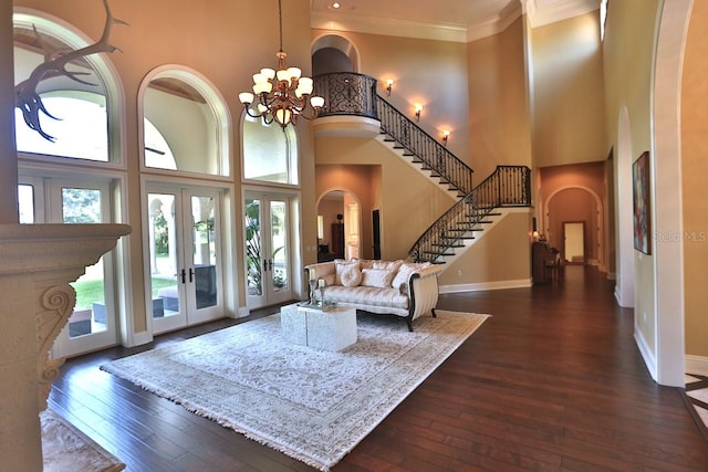 foyer entrance featuring a towering ceiling, french doors, and a wealth of natural light