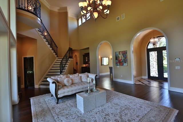 foyer entrance with french doors, a wealth of natural light, a high ceiling, and dark hardwood / wood-style flooring