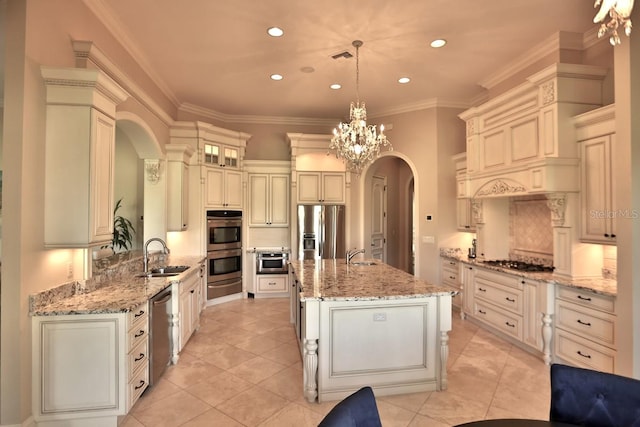 kitchen with a center island with sink, sink, appliances with stainless steel finishes, crown molding, and pendant lighting