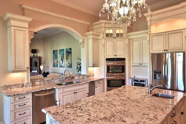 kitchen featuring cream cabinets, light stone counters, and stainless steel appliances