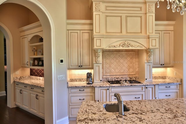 kitchen featuring dark hardwood / wood-style flooring, light stone countertops, cream cabinets, and stainless steel gas stovetop