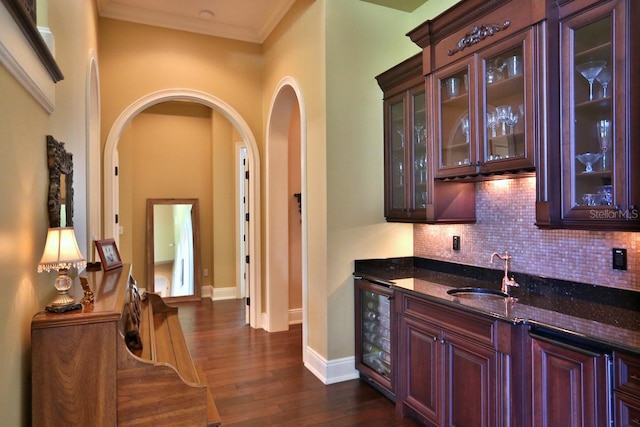 bar with beverage cooler, sink, dark hardwood / wood-style floors, and dark stone countertops