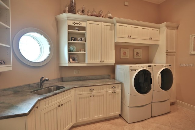 clothes washing area featuring cabinets, washer and dryer, light tile patterned floors, and sink