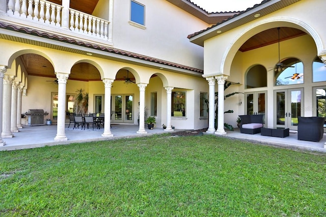 rear view of property with a lawn, a balcony, an outdoor living space, and a patio area