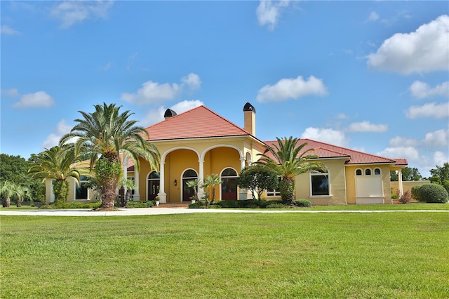 mediterranean / spanish-style house with a front yard