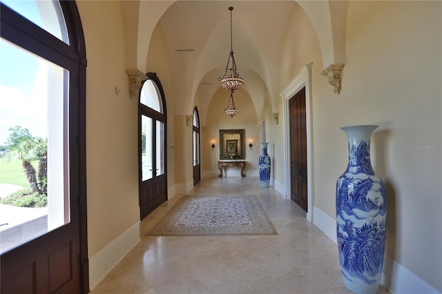 foyer featuring a wealth of natural light, a towering ceiling, and french doors