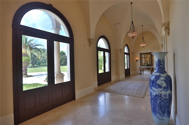 entrance foyer featuring a wealth of natural light, high vaulted ceiling, and french doors