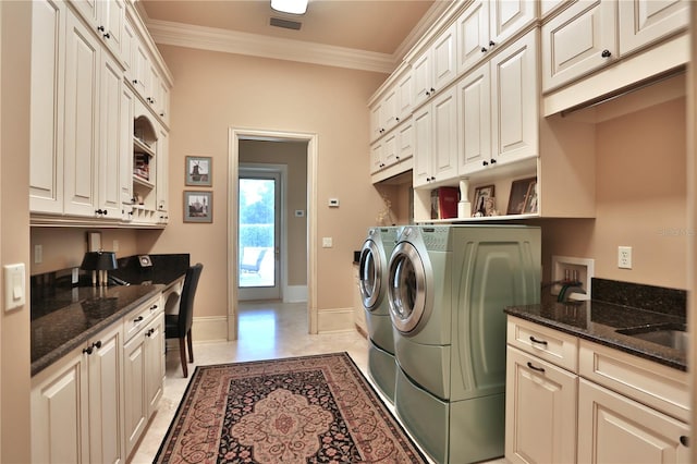 washroom featuring washing machine and clothes dryer, cabinets, sink, and crown molding