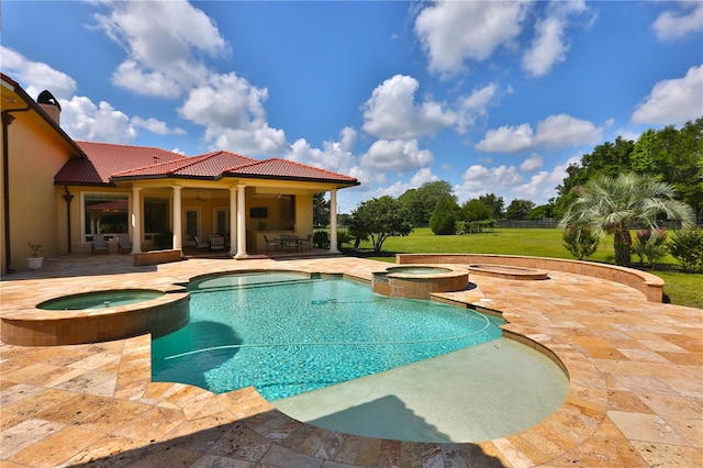 view of pool featuring a patio, a lawn, and an in ground hot tub