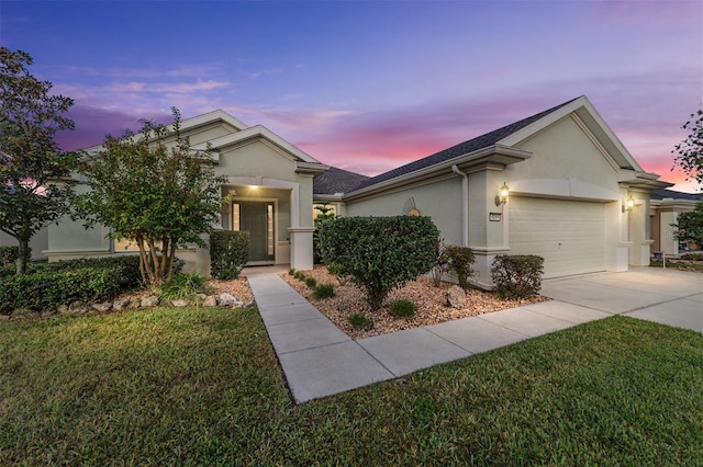 ranch-style home with a garage and a yard