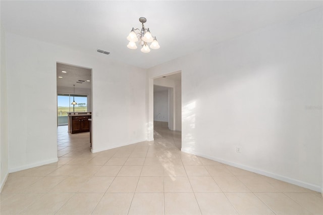 unfurnished room with light tile patterned floors and a chandelier