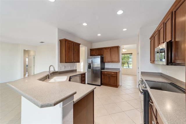 kitchen featuring sink, stainless steel appliances, kitchen peninsula, a breakfast bar area, and light tile patterned floors