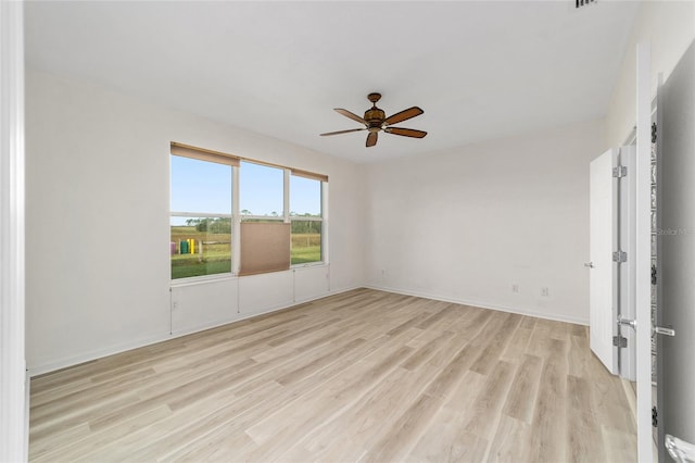 spare room with ceiling fan and light wood-type flooring