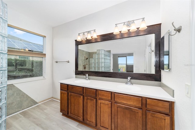 bathroom featuring a shower, a wealth of natural light, hardwood / wood-style floors, and vanity