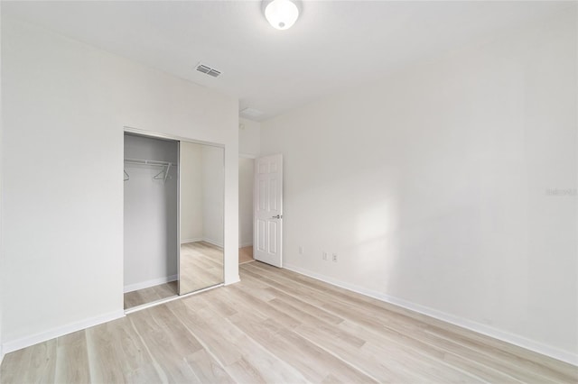 unfurnished bedroom featuring a closet and light wood-type flooring