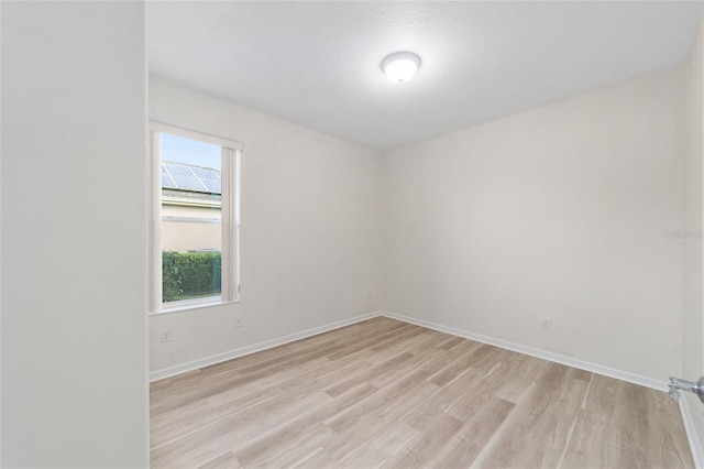 spare room featuring a textured ceiling and light hardwood / wood-style flooring