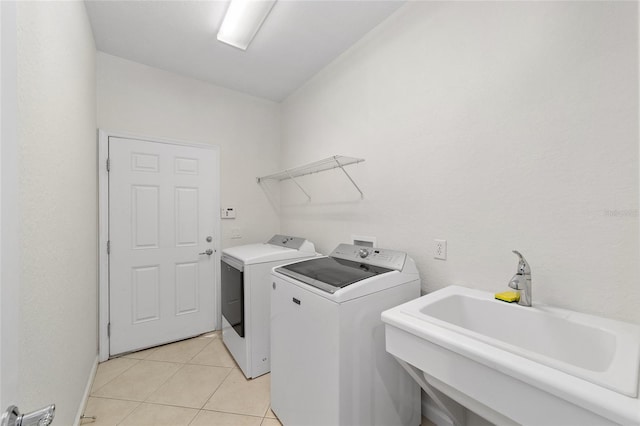 laundry room with sink, light tile patterned floors, and independent washer and dryer