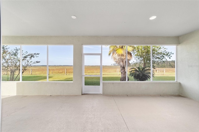 unfurnished sunroom with plenty of natural light and a rural view