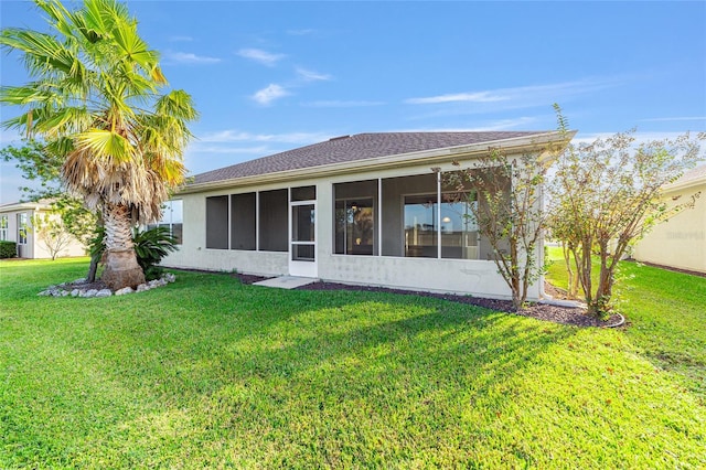 rear view of property with a sunroom and a yard