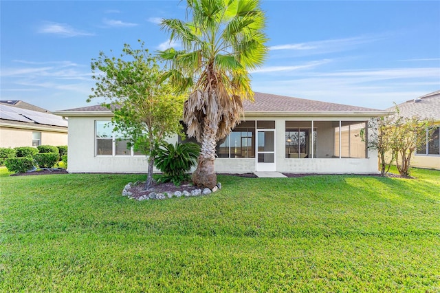 back of property with a sunroom and a yard