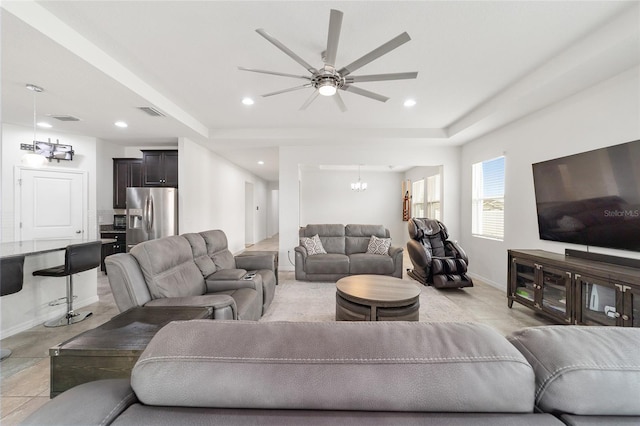 living room with ceiling fan with notable chandelier