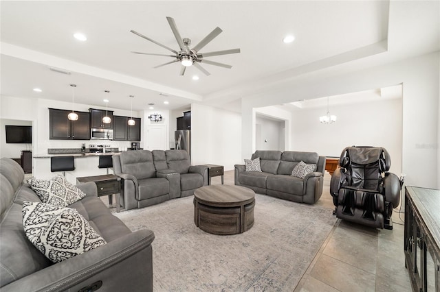 living room with ceiling fan with notable chandelier