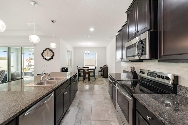 kitchen with appliances with stainless steel finishes, hanging light fixtures, a healthy amount of sunlight, and sink