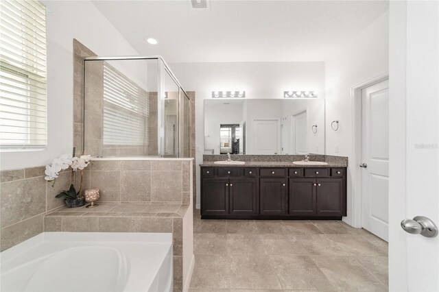 bathroom with vanity, tile patterned flooring, a healthy amount of sunlight, and plus walk in shower