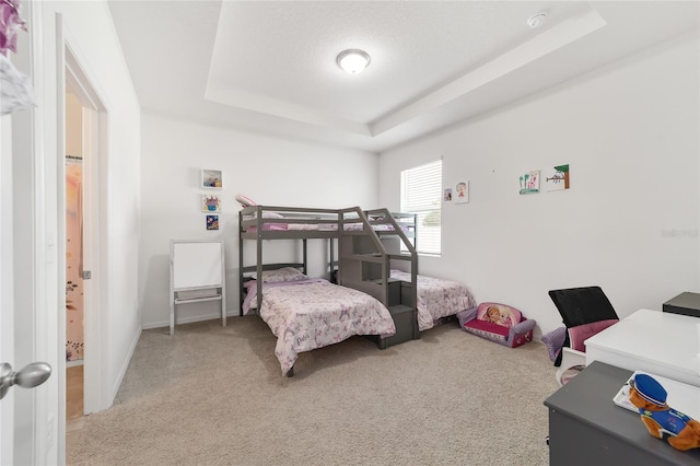 bedroom featuring carpet and a raised ceiling