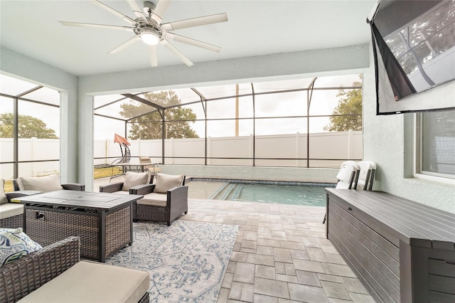 view of pool featuring glass enclosure, a patio area, and ceiling fan