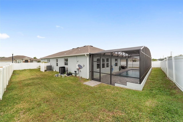 back of house with a lawn, a lanai, a patio, and central AC unit