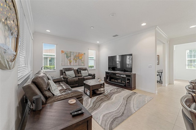 tiled living room with a wealth of natural light, ornamental molding, and a textured ceiling