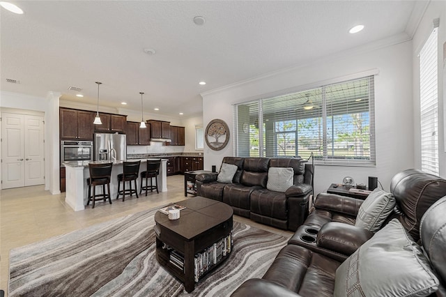 tiled living room featuring ornamental molding and a textured ceiling