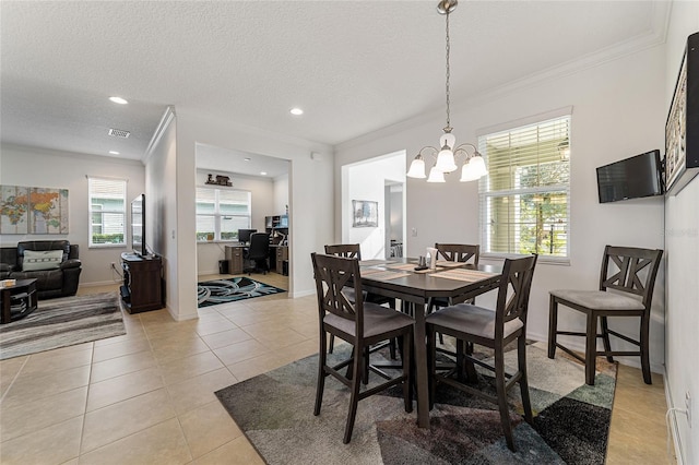 tiled dining room with ornamental molding, a notable chandelier, a textured ceiling, and a healthy amount of sunlight