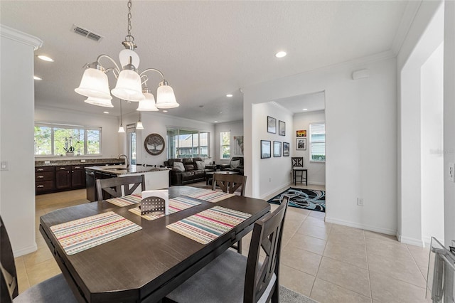 dining room featuring sink, light tile patterned flooring, a textured ceiling, and a wealth of natural light