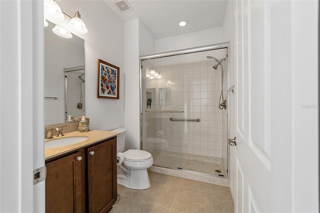 bathroom with toilet, walk in shower, vanity, and tile patterned floors