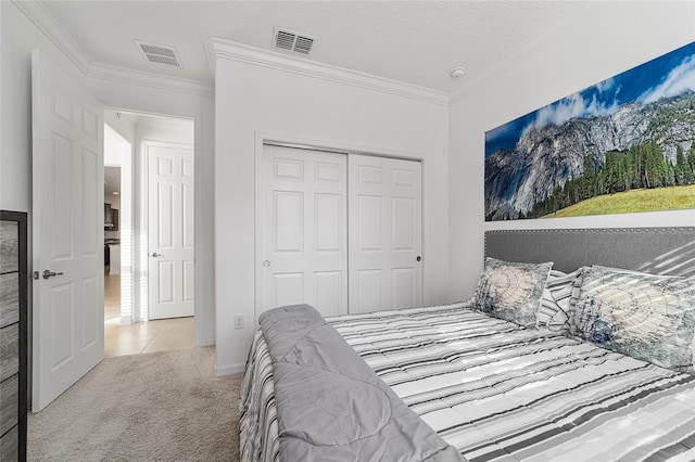 bedroom featuring ornamental molding, a closet, a textured ceiling, and light colored carpet