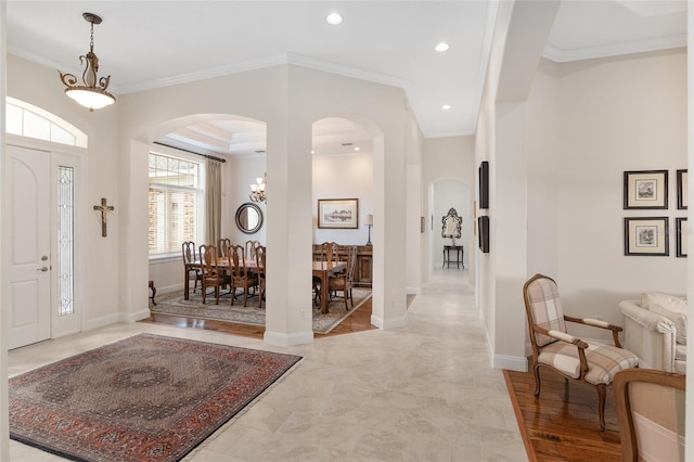 foyer entrance with ornamental molding and light hardwood / wood-style floors