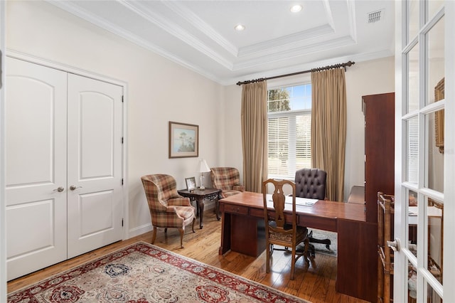 office with hardwood / wood-style flooring, ornamental molding, and a tray ceiling